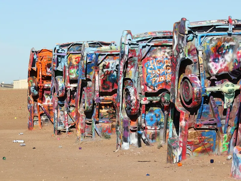 Beschilderde Cadillacs in de grond bij Cadillac Ranch