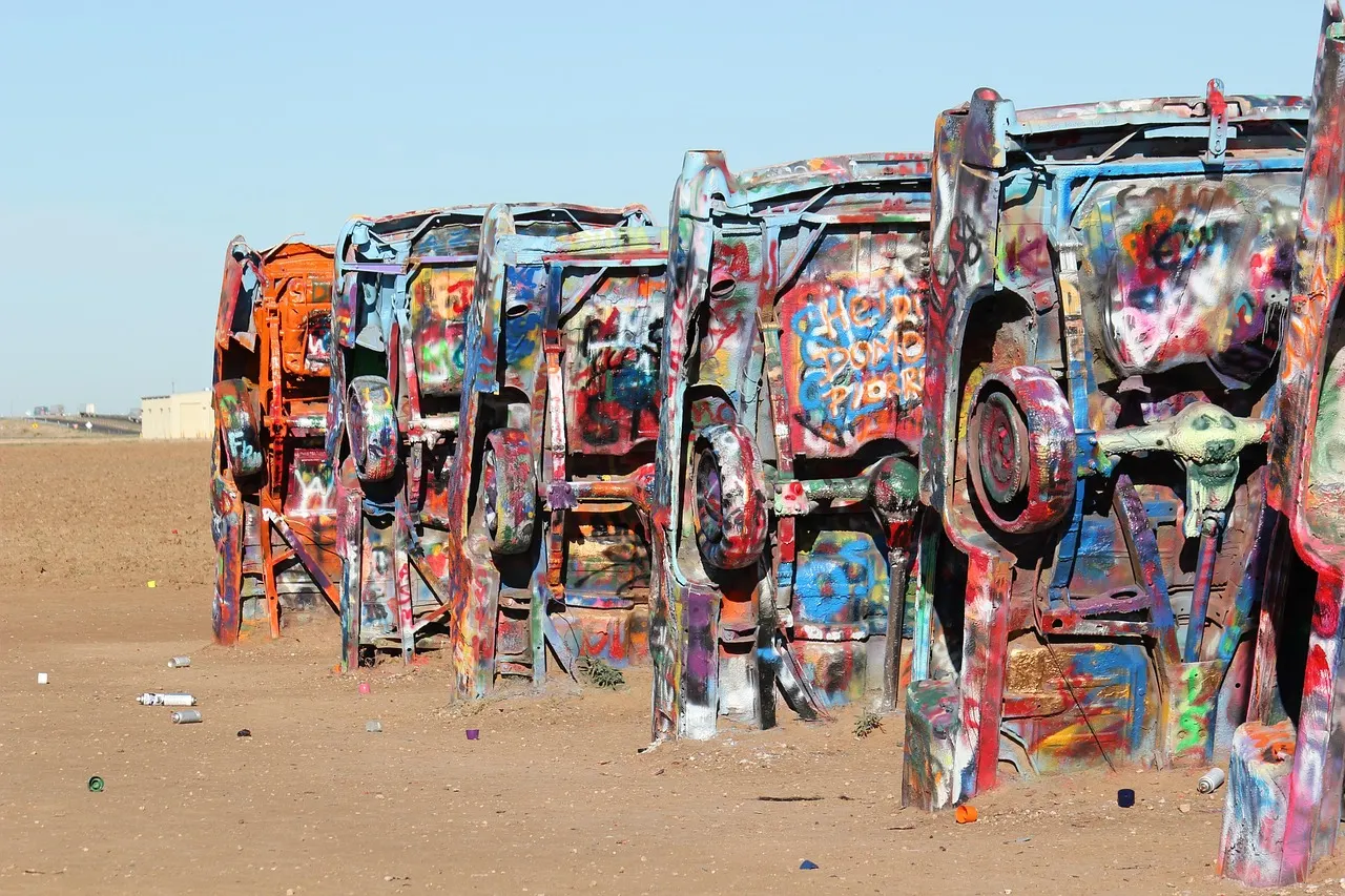 Beschilderde Cadillacs in de grond bij Cadillac Ranch