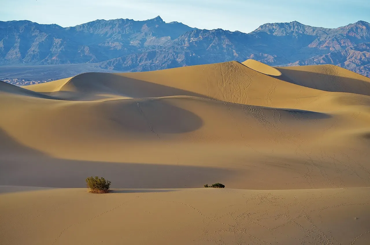 Zandduinen in Death Valley met bergen op de achtergrond