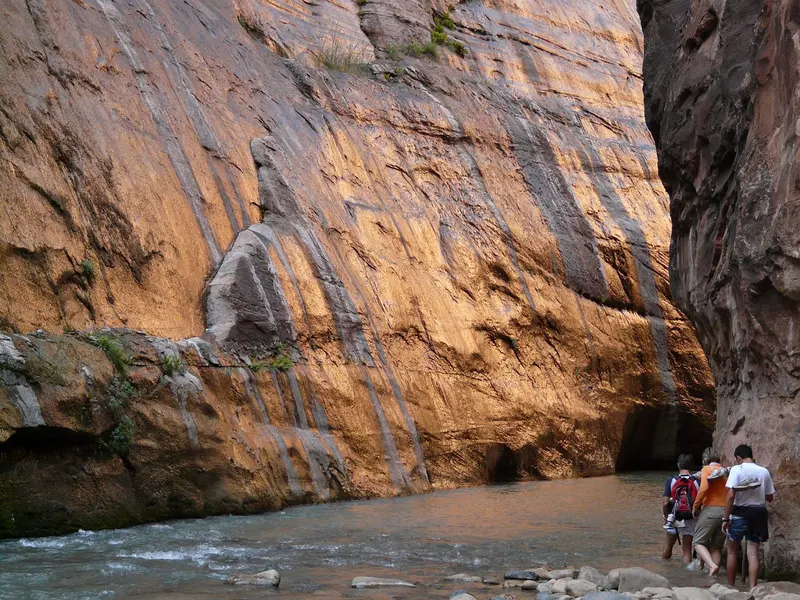 Wandelaars tussen de hoge rotswanden in Zion National Park